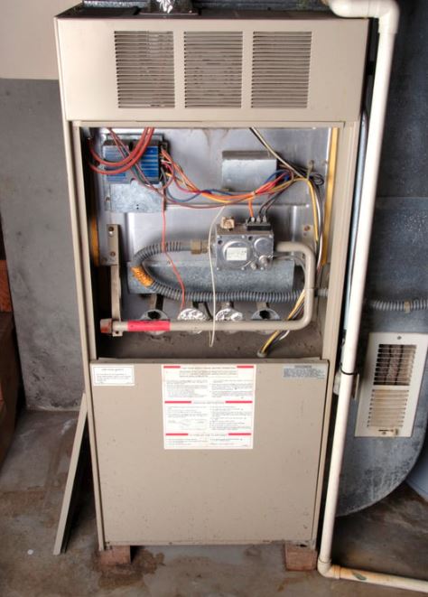 furnace repair 2 Old gas furnace with exposed wiring and components.